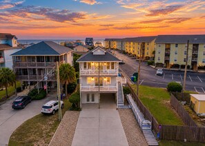 A residential area with multi-story buildings, a parking lot, and a clear sky.