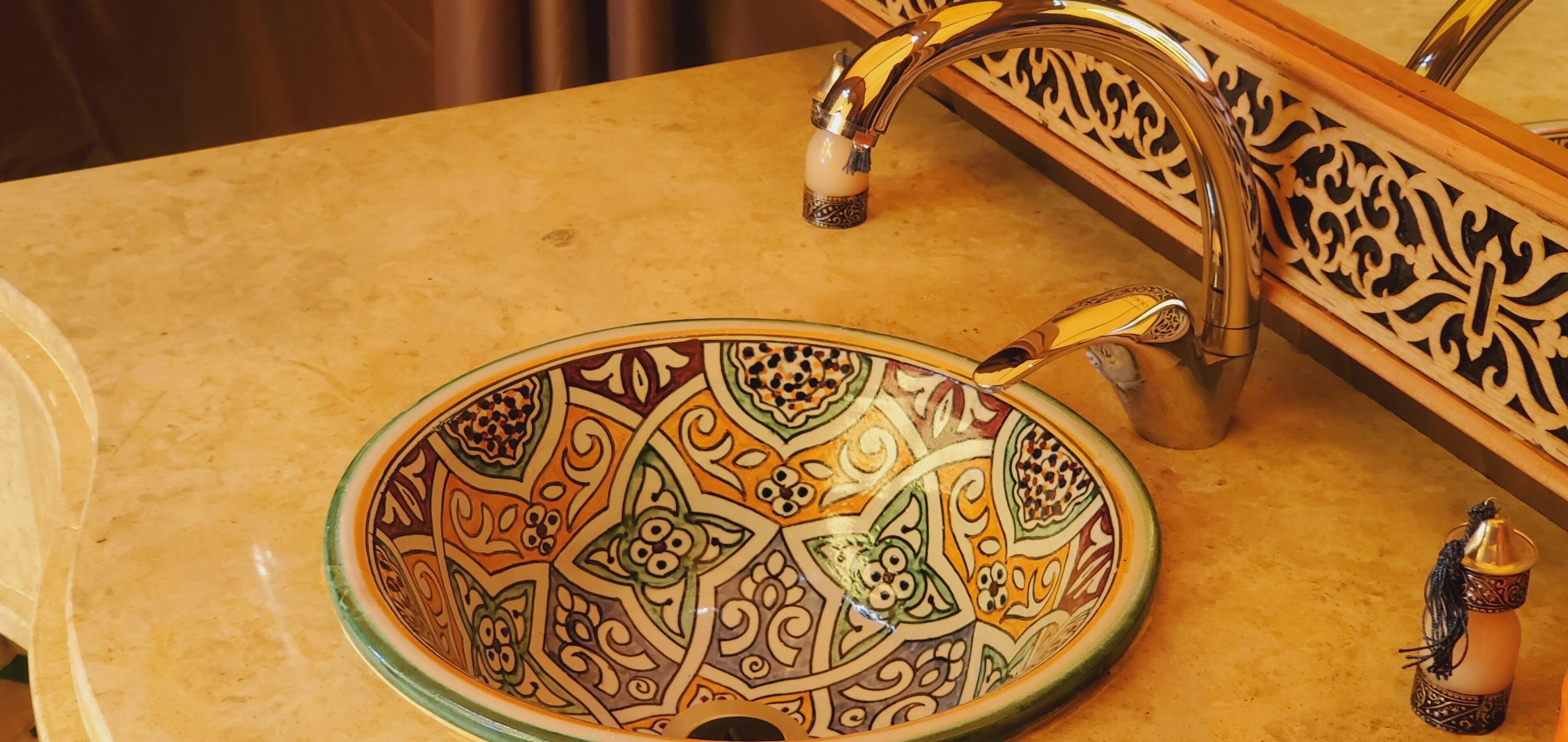 Un lavabo de salle de bain avec un récipient décoratif et un robinet.