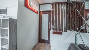 Un interior moderno con una escalera de madera, una recepción y un letrero en la pared.