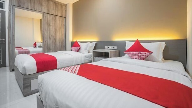 Una habitación de hotel con dos camas, un armario y una mesita de noche.