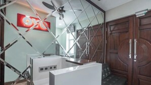 Una habitación moderna con un armario blanco, un ventilador de techo y una puerta de madera.