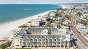 Un hotel costero con varias construcciones, una playa y una carretera.