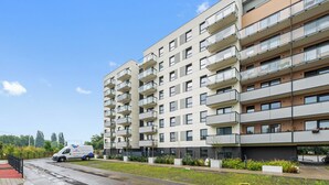 A multi-story residential building with balconies, a paved road, and a van parked in front. - Seaside Latarników by Downtown Apartments (Gdańsk)