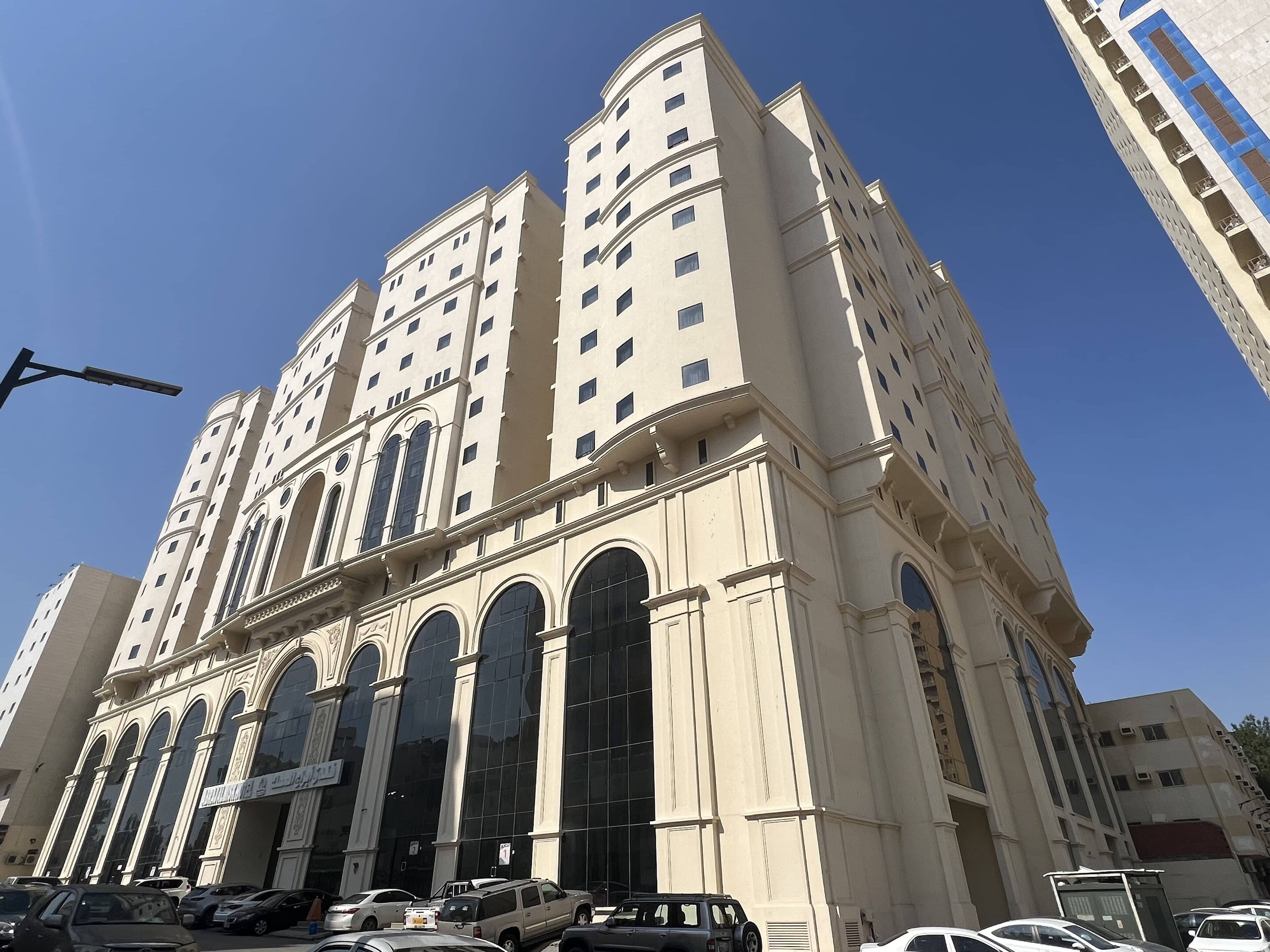 Un edificio de varios pisos con estilo arquitectónico clásico, que presenta amplios ventanales de arco y una fachada simétrica.