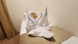A bed with a white towel arranged in the shape of swans with a heart in the center. - ABRAJ ALMISK HOTEL (Makkah)