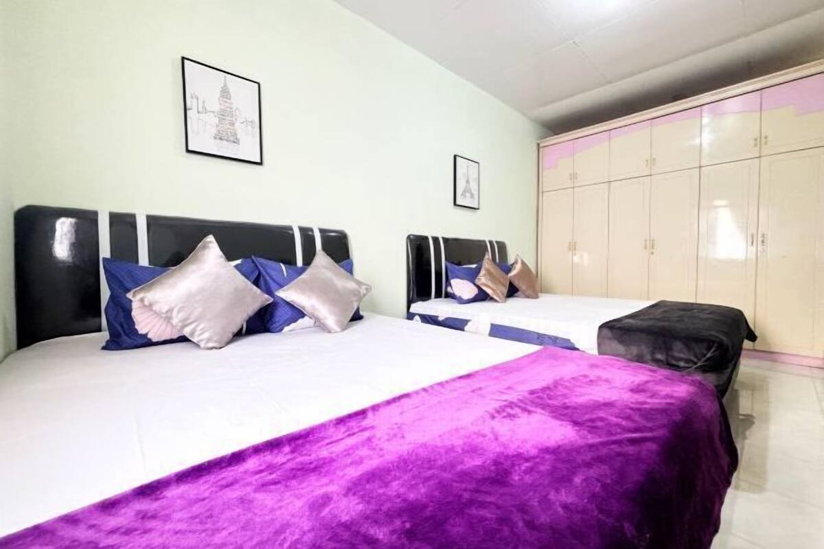 Two beds with headboards, a wardrobe, and a framed picture on the wall.