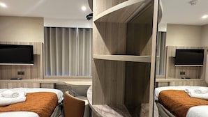 A hotel room with two beds, a seating area, and a TV on the wall. - Mabledon Court Hotel (London)