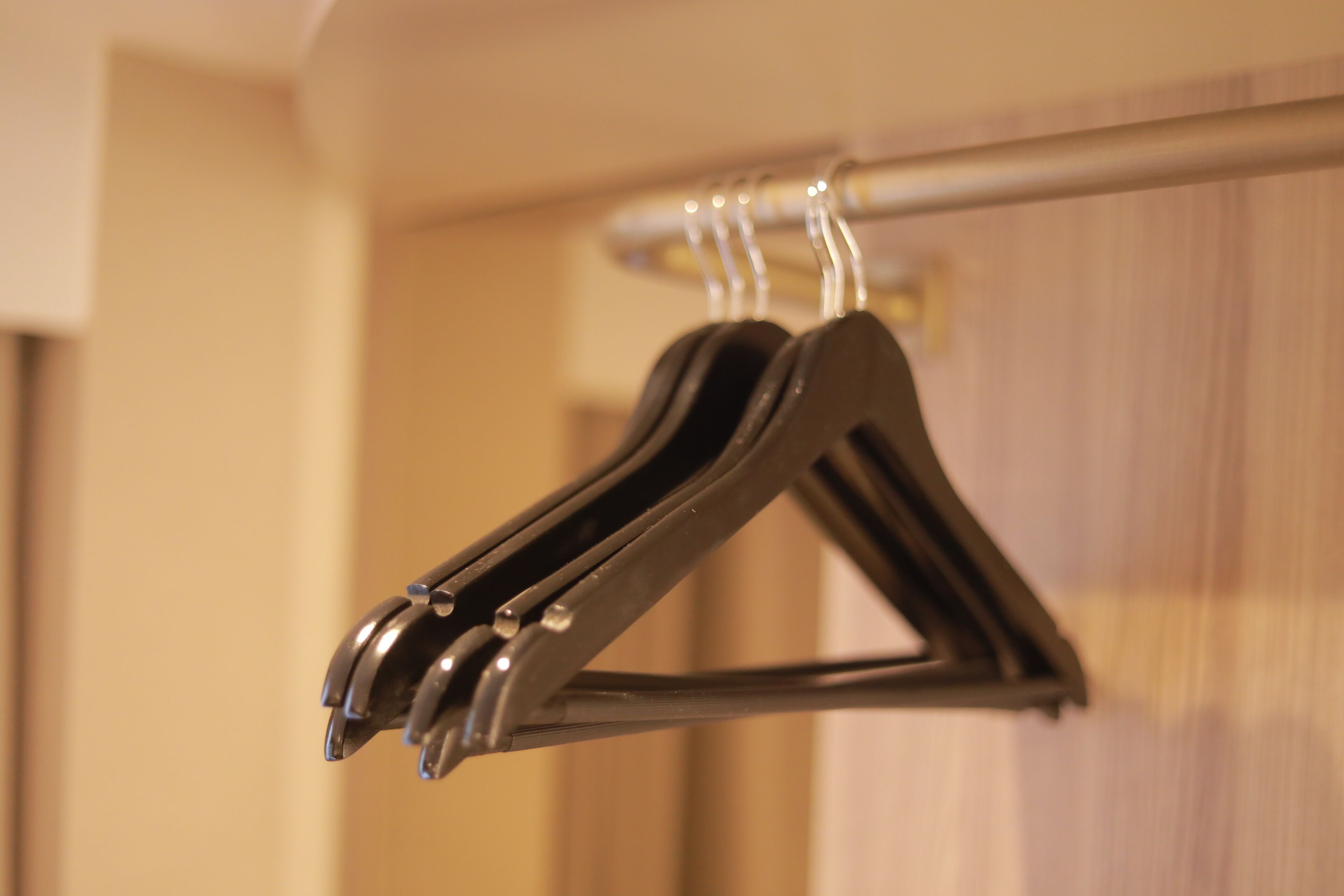 A metal hanger with a folded garment on a wall-mounted rack.
