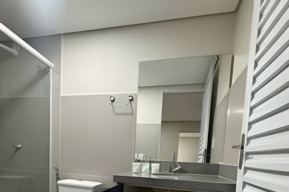 A modern bathroom with a toilet, sink, and shower.