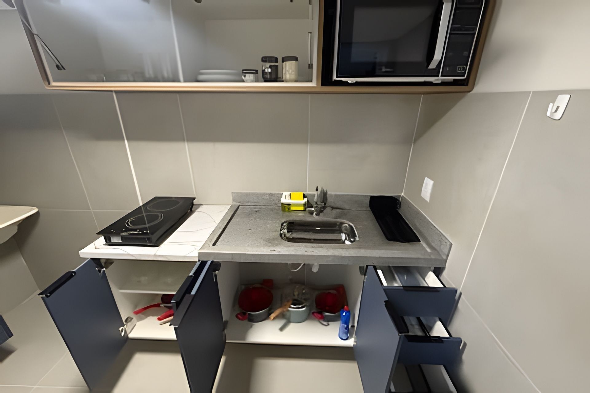 A kitchen with a stove, microwave, sink, and cabinets.