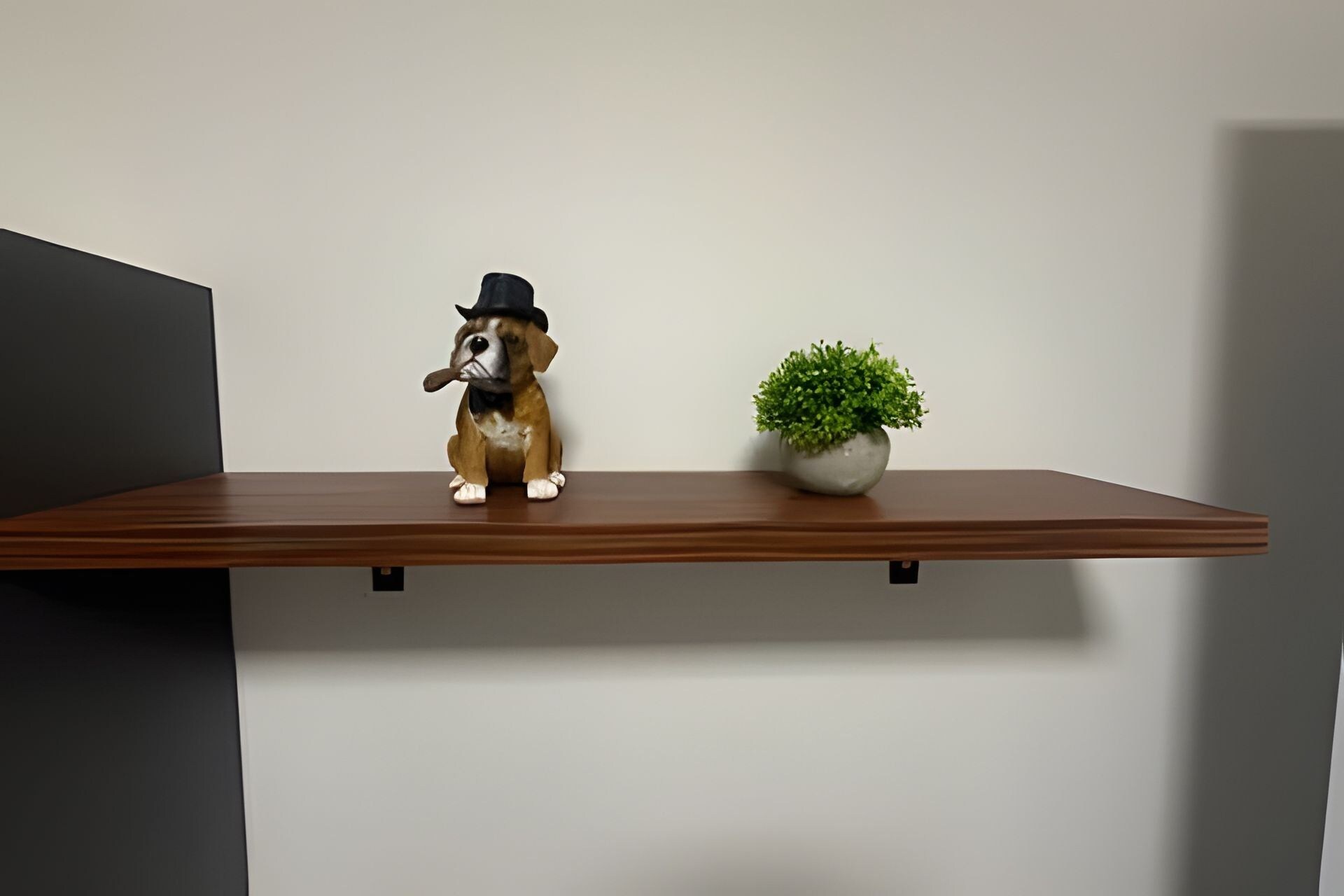 A shelf with a dog figurine and a potted plant.