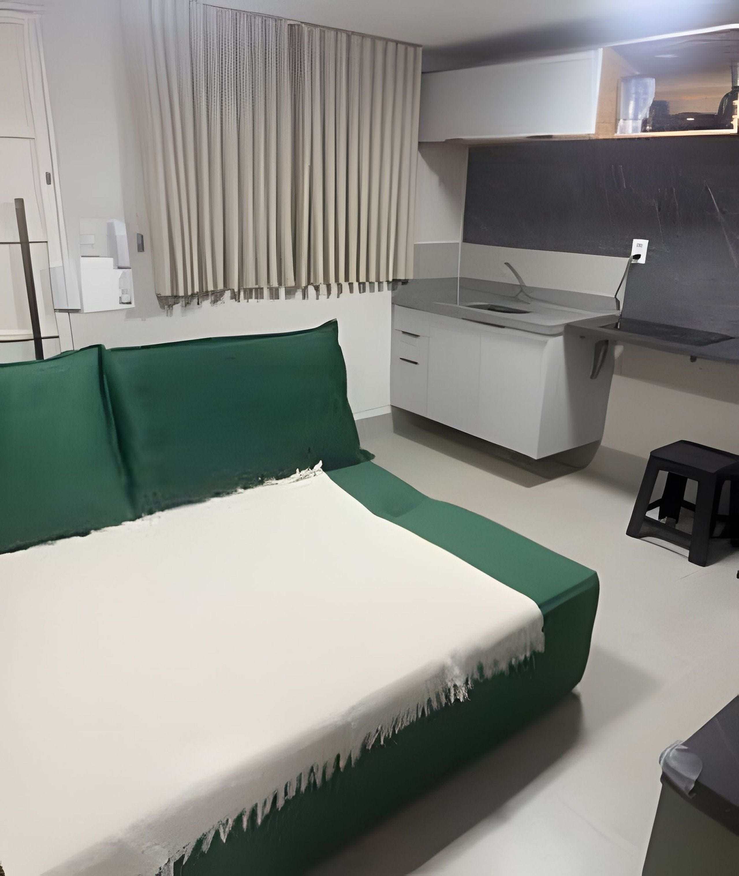 A bedroom with a bed, a desk, and a chair.
