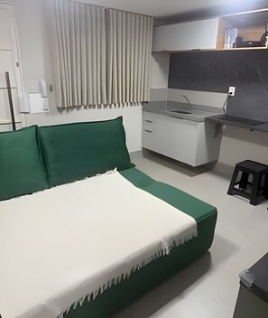 A bedroom with a bed, a desk, and a chair. - Studios Jocatita (Cuiabá)