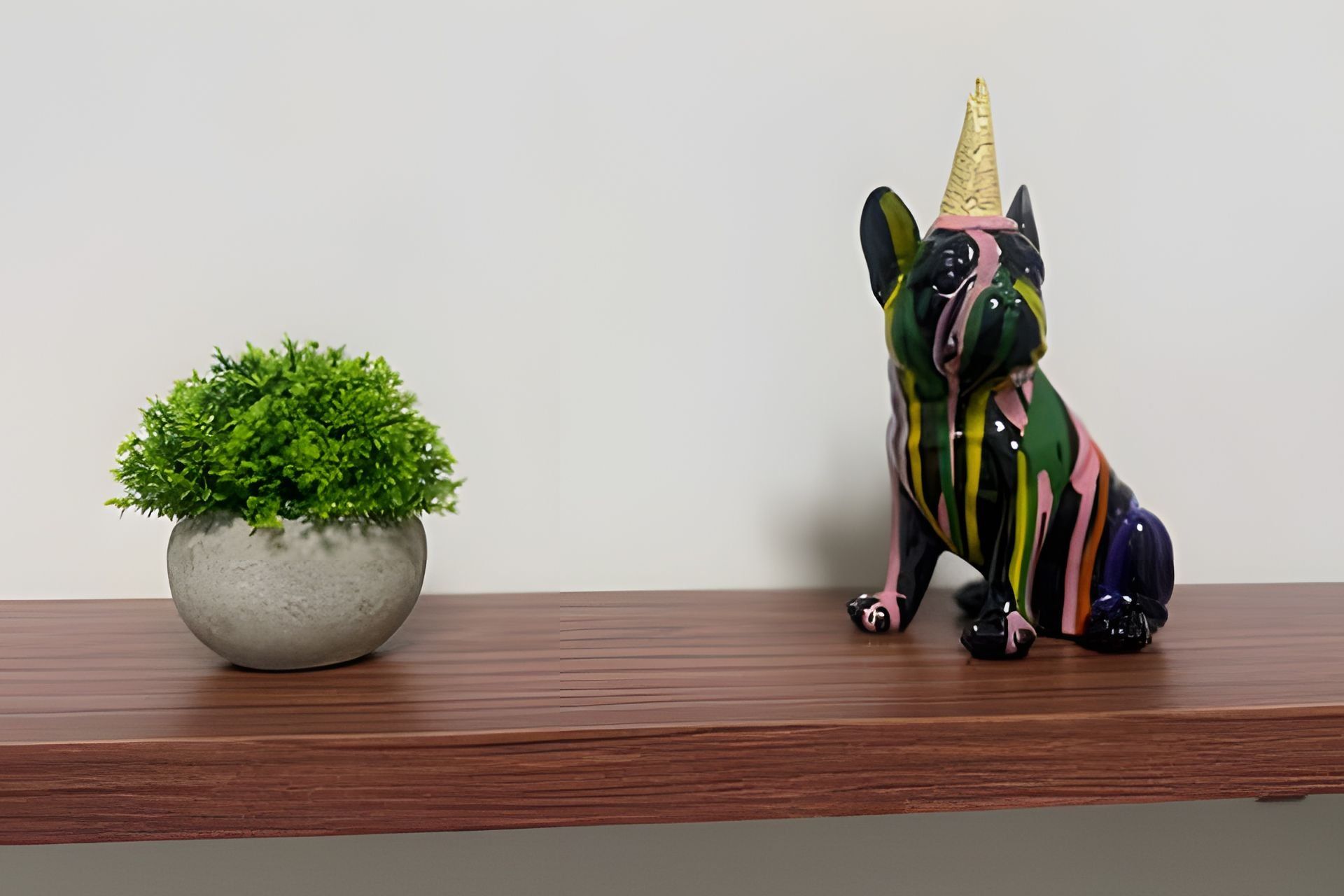 Une plante en pot et une figurine de licorne multicolore, posées sur une étagère en bois.