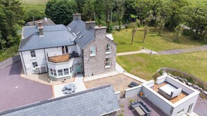 Une grande maison dotée d’un vaste patio, d’une maison d’hôtes séparée et d’une pelouse bien entretenue.