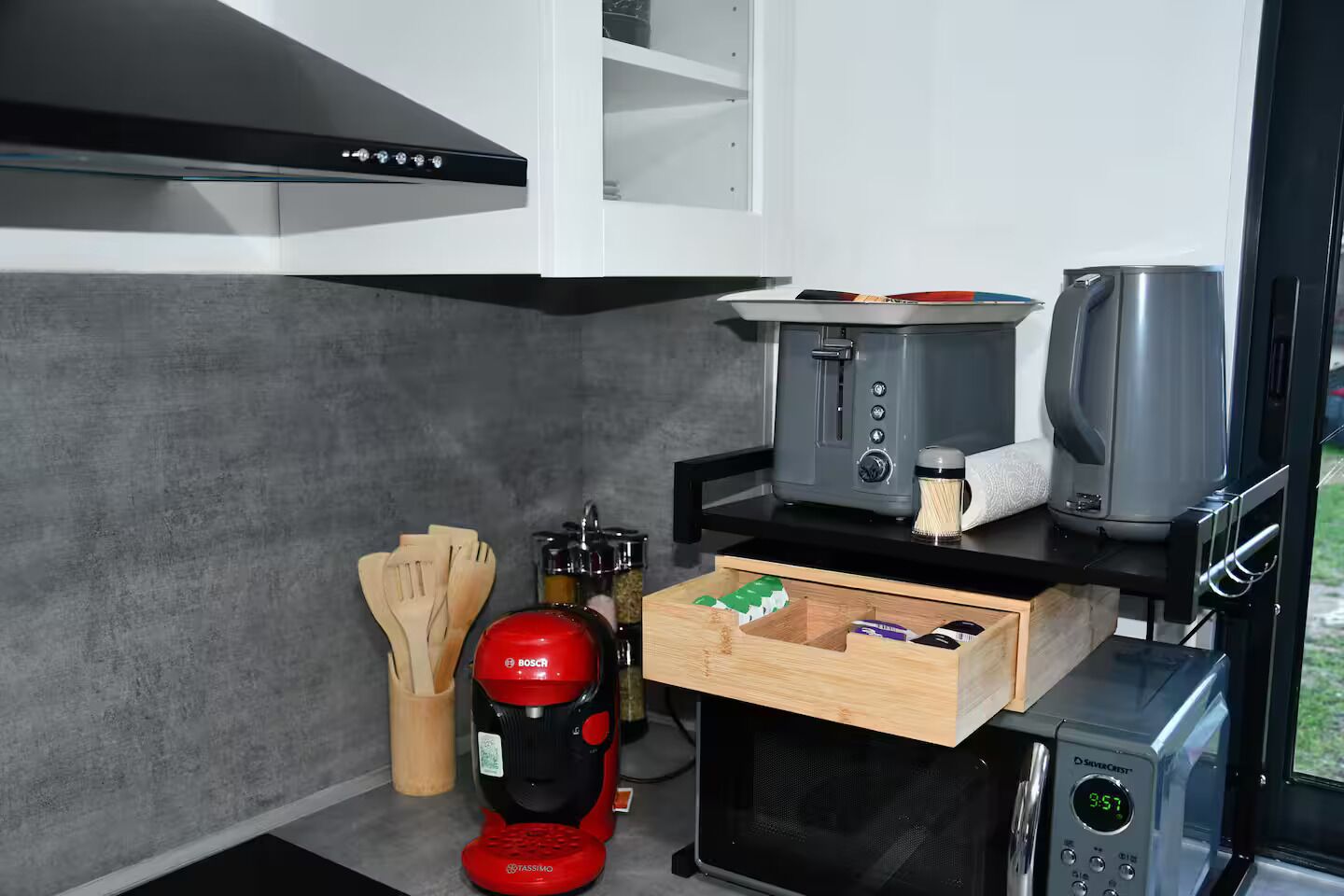 A compact kitchen with a toaster, coffee maker, and espresso machine.
