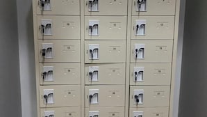 A row of beige lockers with numbered compartments, each with a keyhole. - Hide Hostel (Koh Phangan)