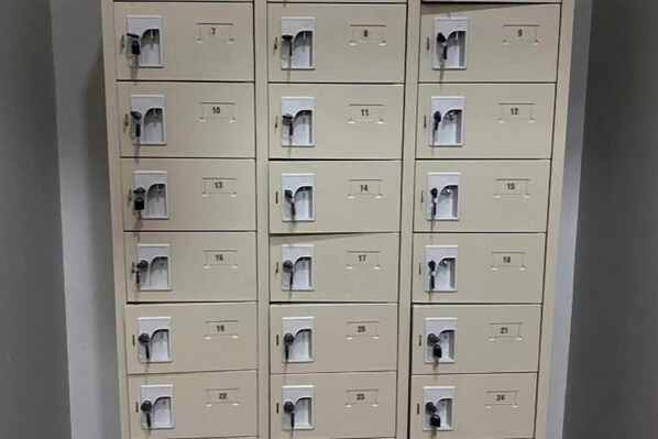 A row of beige lockers with numbered compartments, each with a keyhole.