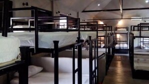 A dormitory-style room with bunk beds arranged in rows. - Hide Hostel (Koh Phangan)