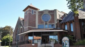 A building with a prominent circular window and a brick facade. - Harbour Grove Sanctuary w Garage , Quiet & Private (Cremorne)