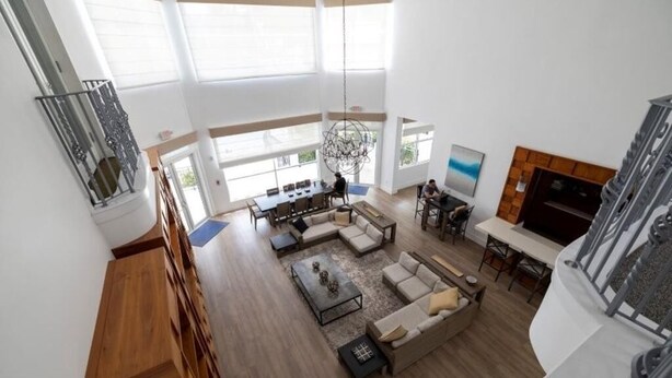 A spacious living area with a high ceiling, large windows, a fireplace, and a dining area. - 2-bedroom condo in beautiful Aventura with AC, Swimmimg pool and fitness room (Aventura)