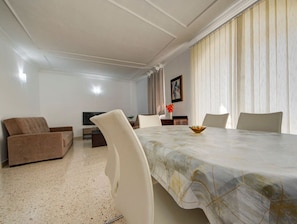 A spacious living room with a large dining table, two sofas, and a television. - Authentic Maltese 3BR home with Terrace in Mosta! (Mosta)
