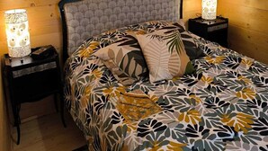 Una stanza con pannelli in legno, un letto, due comodini e un decoro circolare a parete.