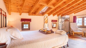 A wooden ceiling, a bed with pillows, a tray with breakfast items, a chair, and a window with curtains. - Peaceful Village Escape (Sales)