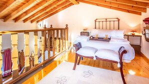A bedroom with a wooden ceiling, a bed with pillows, a nightstand, and a window. - Peaceful Village Escape (Sales)