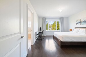 A hotel room with a bed, a desk, and a window with curtains. - Family Townhome at Blue with Resort Shuttle (The Blue Mountains)