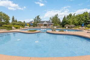 A large outdoor swimming pool with multiple lanes, surrounded by lounge chairs and umbrellas. - Family Townhome at Blue with Resort Shuttle (The Blue Mountains)