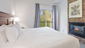 A hotel room with a large bed, a fireplace, and a balcony with curtains. - Collingwood Hideaway for 6 | 10 Mins to Blue Mtn (Collingwood)