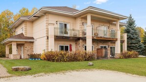 A two-story house with a stone facade, a covered front porch, and a landscaped yard. - Collingwood Hideaway for 6 | 10 Mins to Blue Mtn (Collingwood)
