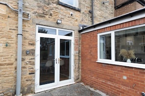 A stone building with a white-framed glass door and a brick extension. - Central Bishop - 4 Beds, Games Room, Secure Parking (Bishop Auckland)