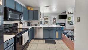 Una cocina moderna con armarios azul oscuro, un microondas negro y una estufa de acero inoxidable.