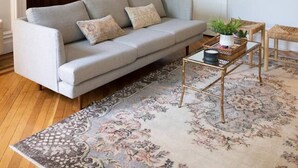 A living room with a grey sofa, a patterned rug, a wooden coffee table, and a chandelier. - Charming Apt. with Marble Mantel (Troy)