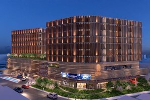 A modern building with a curved facade, multiple floors, and a landscaped area with pathways and greenery. - Dalat Center Residence (Dalat)