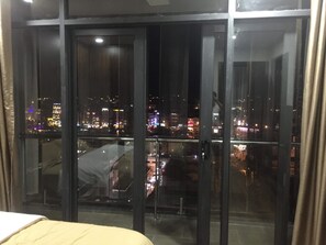 A room with a large window overlooking a cityscape at night. - Dalat Center Residence (Dalat)
