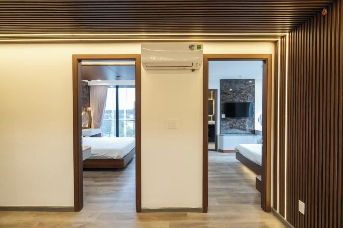 A hotel room with a bed, a bathroom, and a kitchenette.