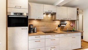 Eine moderne Küche mit eingebauten Geräten, einer Holz Arbeitsplatte und einer Spüle aus Edelstahl.