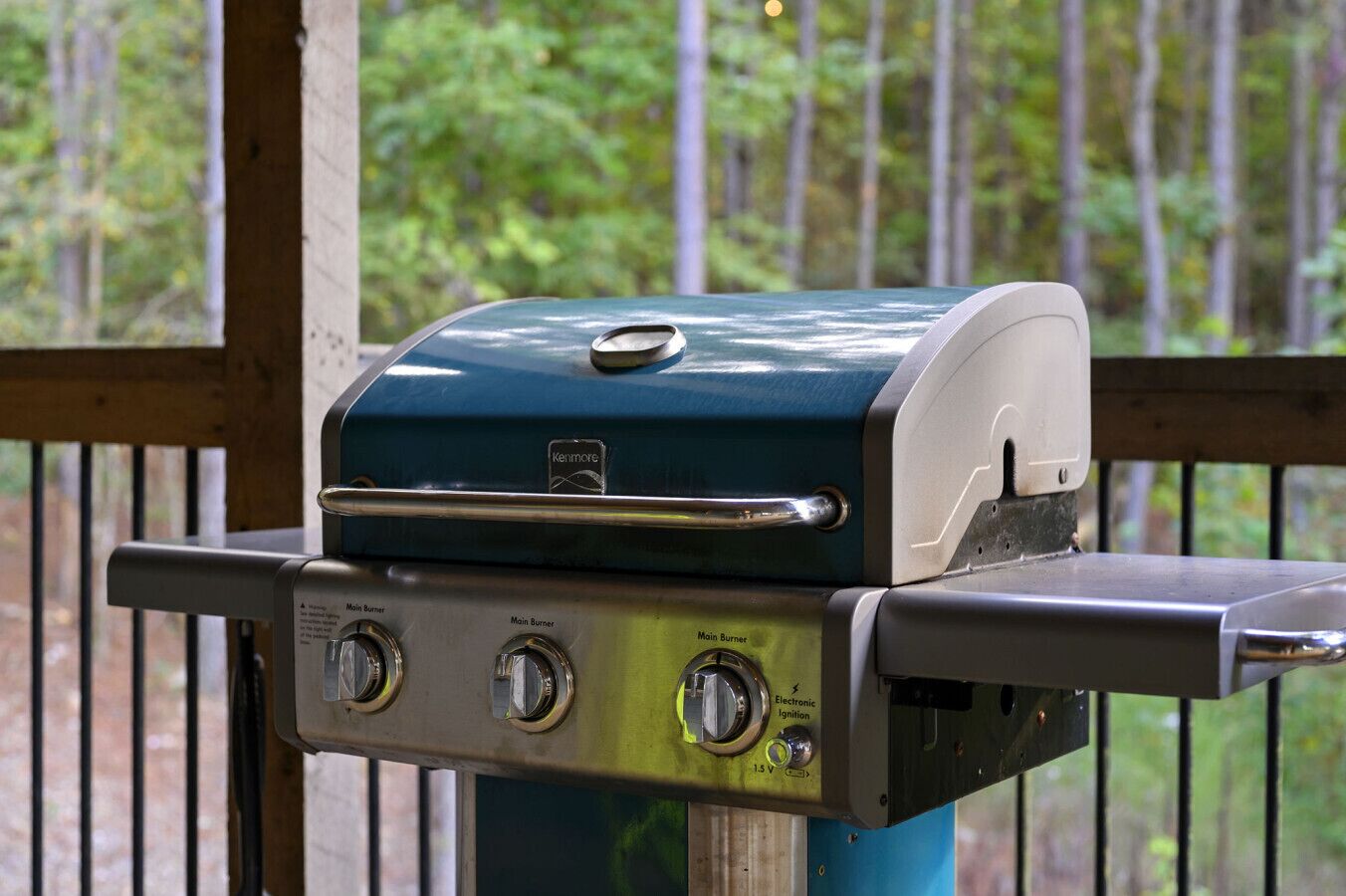 A Kenmore grill with a digital display and two main burners, mounted on a metal stand.