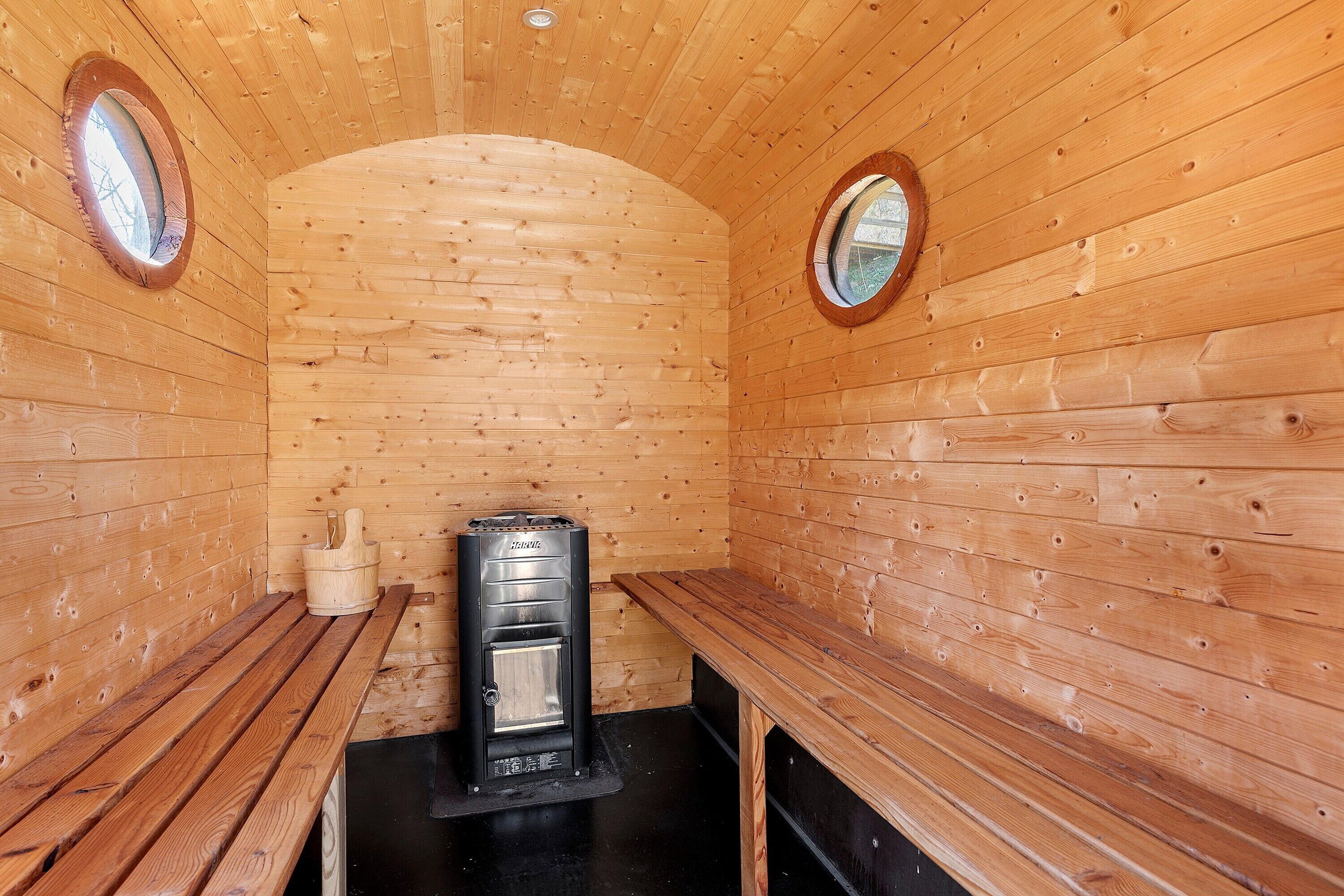 Un cuarto de sauna con paredes, bancos y equipo de madera.