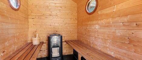 Un cuarto de sauna con paredes, bancos y equipo de madera.