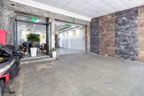 A lobby with a marble floor, a reception desk, and a potted plant. - Rita Hotel near Tan Son Nhat Airport (Ho Chi Minh City)