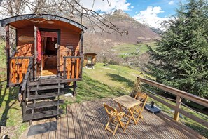 Une cabane en bois avec une terrasse, une table et des chaises.