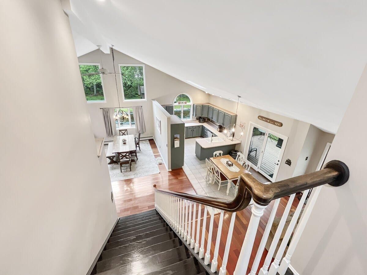 A modern interior with a staircase leading to a dining area and kitchen.