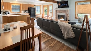 A spacious living area with a fireplace, a dining table with chairs, and a sofa. - Hidden Kingdom in Plymouth (Plymouth)