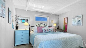 A bedroom with a bed, a nightstand, a dresser, a window, and wall art. - Admiral s Quarters in Wells (Wells)
