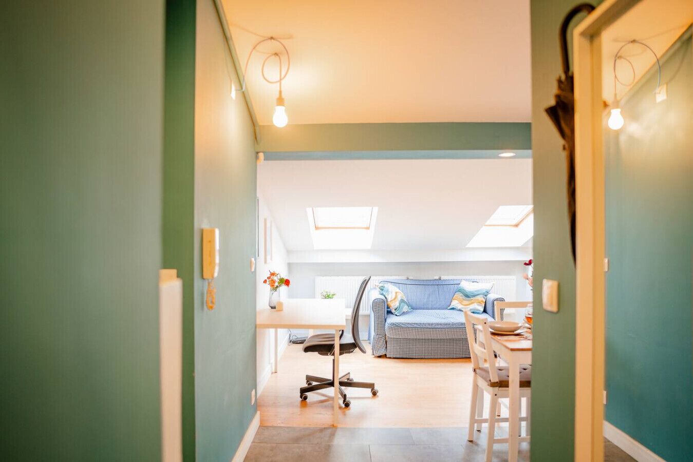 Un intérieur moderne comprenant un coin repas, un canapé et un plafond doté de lucarnes.