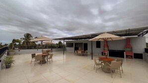 A rooftop patio with outdoor seating and a brick oven. - Apto c Piscina e 2 su tes a Poucos Passos da Praia (Japaratinga)